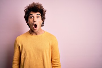 Young handsome man wearing yellow casual t-shirt standing over isolated pink background afraid and shocked with surprise expression, fear and excited face.