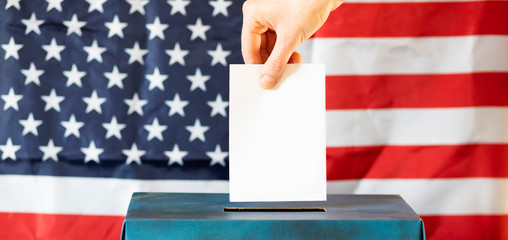 usa elections  the hand of woman putting her vote in the ballot box