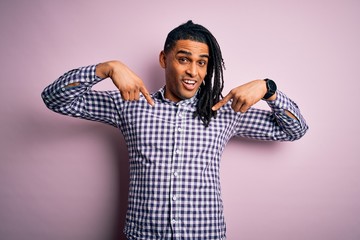 Young handsome african american afro man with dreadlocks wearing casual shirt looking confident...
