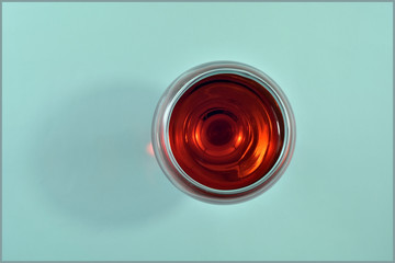  Glass of red wine on a light green background