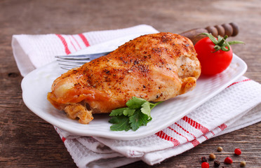 Baked chicken breast in a plate on a dark background