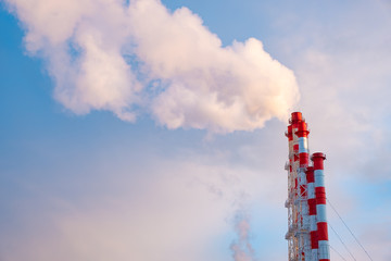 Smokestacks against a clear blue sky. Smoke from the pipes of thermal power plants that supply heat to the city. Pipes of factories. Environmental issues and the concept of global warming