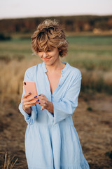 woman in Euphoria, look at your phone grinning while waiting for a call.