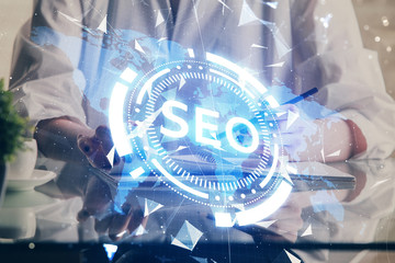 Multi exposure of woman's hands making notes with SEO icon. Concept of Search engine optimization