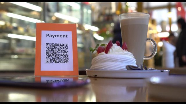 QR code cashless payment. Scan to pay system. Business or technology concept: using smartphone for scanning QR code for paying in the cafeteria