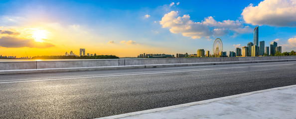 Empty asphalt road and beautiful city skyline with buildings at sunset in Suzhou,panoramic view.