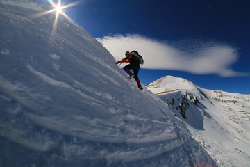 Mountaineer man climbing a snowy mountain