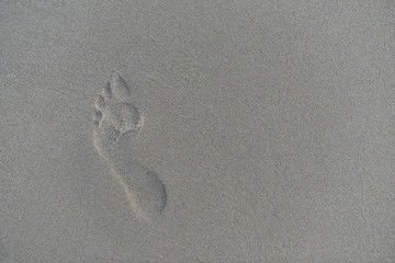 trace of a human bare foot on the bleach sand