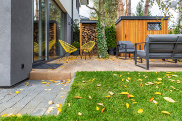 Yellow armchairs and grey sofas in the garden of single family home