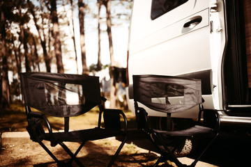 Camping Stühle vor dem Van im Wald bei Sonne