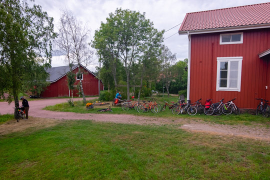 Finland, Aland Islands, Lappo, A group of cyclists getting ready to park bikes at the hotel in the small and beautiful Finnish Swedish town of Lappo on the Aland Islands.