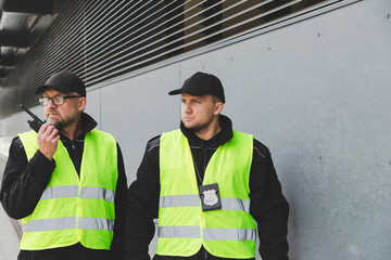 Policemen in reflective vests looking around carefully during patrol in the city center