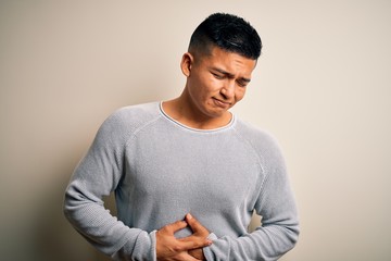 Young handsome latin man wearing casual sweater standing over isolated white background with hand...