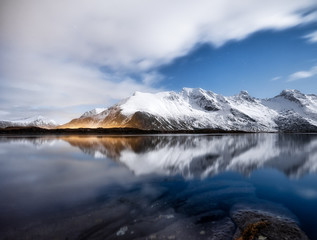 Fototapeta na wymiar Mountains and night sky, Lofoten islands, Norway. Reflection on the water surface. Winter landscape with night sky. Long exposure shot. Norway travel - image