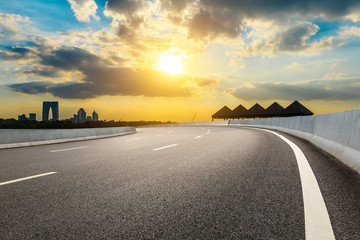 Empty asphalt road and beautiful city skyline with buildings at sunset in Suzhou.