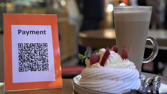 QR code cashless payment. Scan to pay system. Business or technology concept: using smartphone for scanning QR code for paying in the cafeteria