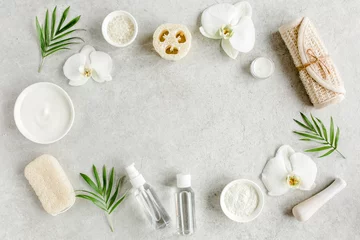 Foto auf Glas Spa treatment concept. Natural/Organic spa cosmetics products, sea salt, massage brush, tropic palm leaves on gray marble table from above. Spa background with a space for a text, flat lay, top view © K.Decor