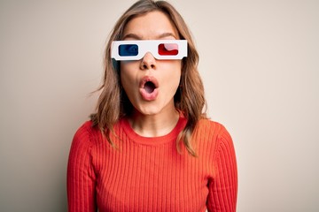 Young blonde girl wearing 3d cinema glasses over isolated background afraid and shocked with surprise expression, fear and excited face.