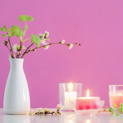 spring cherry flowers and candles on pink background
