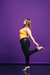 Plus size fashion model in casual clothes, fat woman on purple background