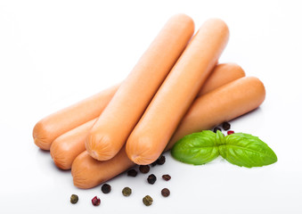 Classic boiled meat pork sausages with pepper and basil on white background.