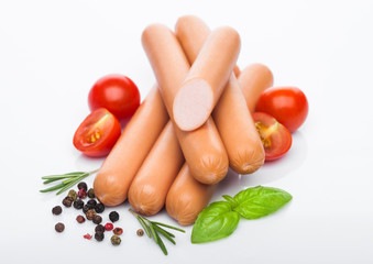 Classic boiled meat pork sausages with pepper and basil and cherry tomatoes on white background. Top view