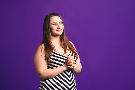Happy plus size model in striped dress, fat woman on purple background