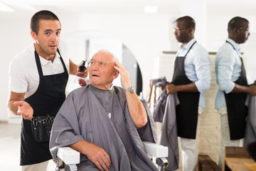 Senior man unpleasantly surprised by haircut
