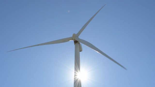 Wind turbine of renewable energy moving with sunshine at blue sky a sunny day