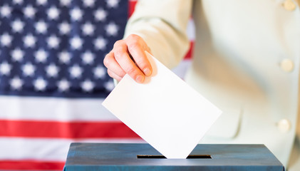 usa elections  the hand of woman putting her vote in the ballot box