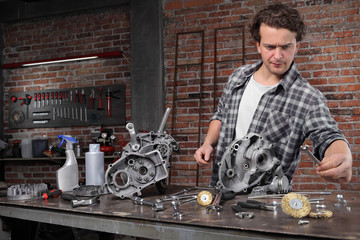 man work choose the wrench for repair and cleaning engine parts on the workbench in home garage workshop, diy concept