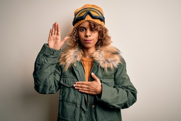 Young african american skier woman with curly hair wearing snow sportswear and ski goggles Swearing...
