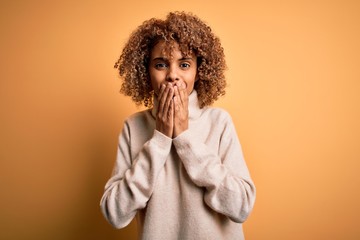 Young beautiful african american woman wearing turtleneck sweater over yellow background laughing...
