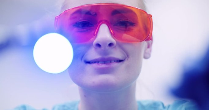 dentist using UV hardener during surgey at healthcare clinic