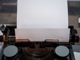 old vintage typewriter with a sheet of white paper