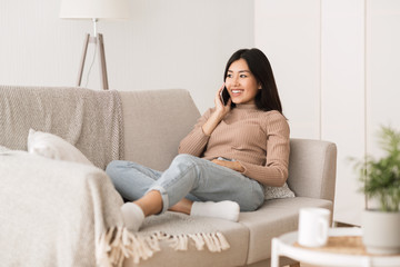 Obraz premium Relaxed girl chatting on phone, smiling and listening to call