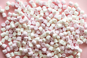 Background or texture of pink and white mini marshmallows on pink background