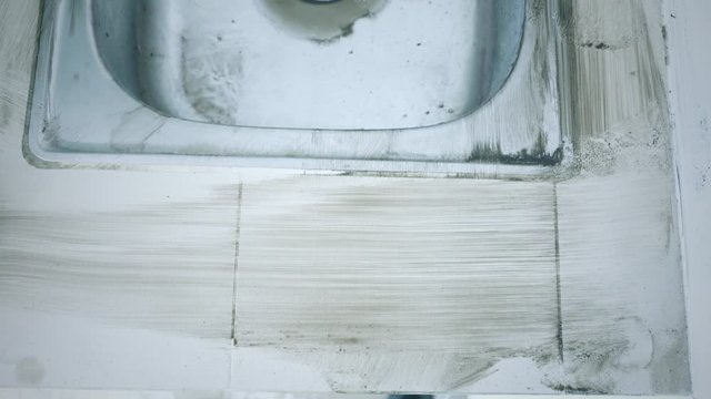 Male worker hands scrubbing dirty kitchen sink