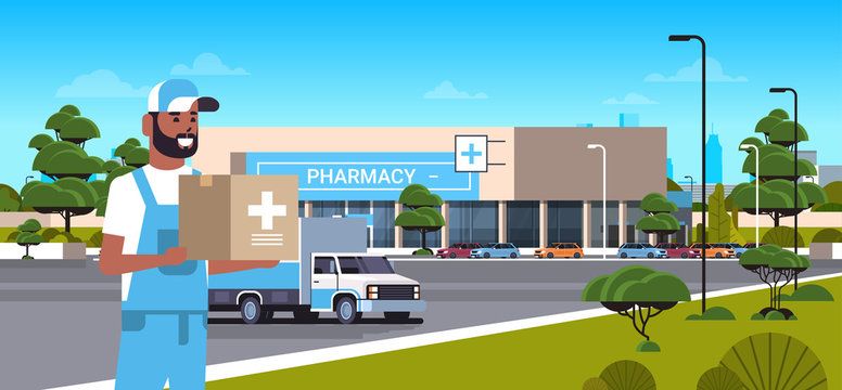deliveryman carrying medical products in cardboard box with cross sign modern drugstore front view pharmacy store building exterior medicine healthcare delivery service concept horizontal portrait
