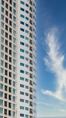 Fototapeta premium Tall condomiium tower with windows and balcones against nice sky
