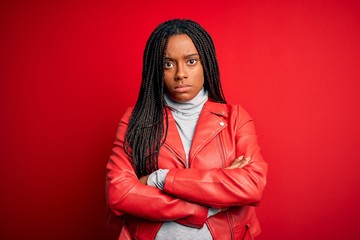 Young african american woman wearing cool fashion leather jacket over red isolated background...