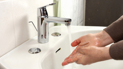 Unrecognisable man washing hands