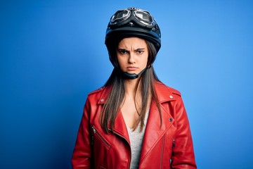 Young beautiful brunette motorcycliste woman wearing motorcycle helmet and jacket skeptic and nervous, frowning upset because of problem. Negative person.