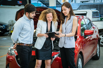 Successful business couple buying a new car at car dealership.