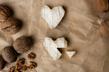 Neufchatel, French cheese made in Normandy from cow's milk. with walnut kernels on a wooden wooden background. Copy space white mold growing