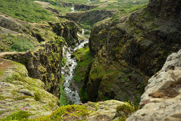 Fototapeta na wymiar Botsna river canyon. Amazing green landscape of Icelandic Canyon. Fantastic misty weather, seagulls soaring over cliffs