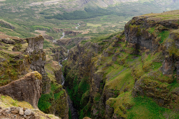 Botsna river canyon. Amazing green landscape of Icelandic Canyon. Fantastic misty weather, seagulls soaring over cliffs