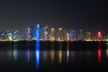 Fototapeta na wymiar Vibrant Skyline of Doha at Night as seen from the opposite side of the capital city bay at night