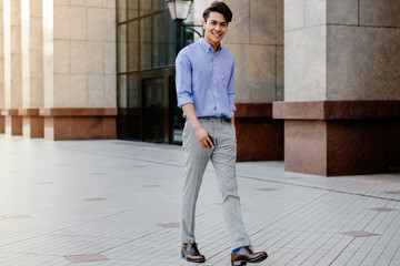 Happy Young Businessman in Casual wear Walking in the City. Lifestyle of Modern People. Looking at the Camera. Full Length