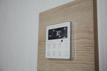 air conditioner screen on the wall that shows an air temperature of 30 degrees Celsius